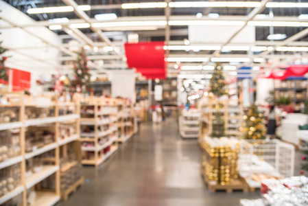 模糊五颜六色的排, 货架上的塑料圣诞钟饰品, 花环, 灯饰和人工圣诞树装饰在大型家具仓库出售。散景灯背景