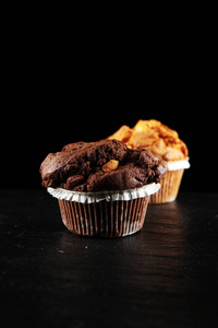 巧克力松饼和坚果松饼, 在黑暗背景下自制面包店