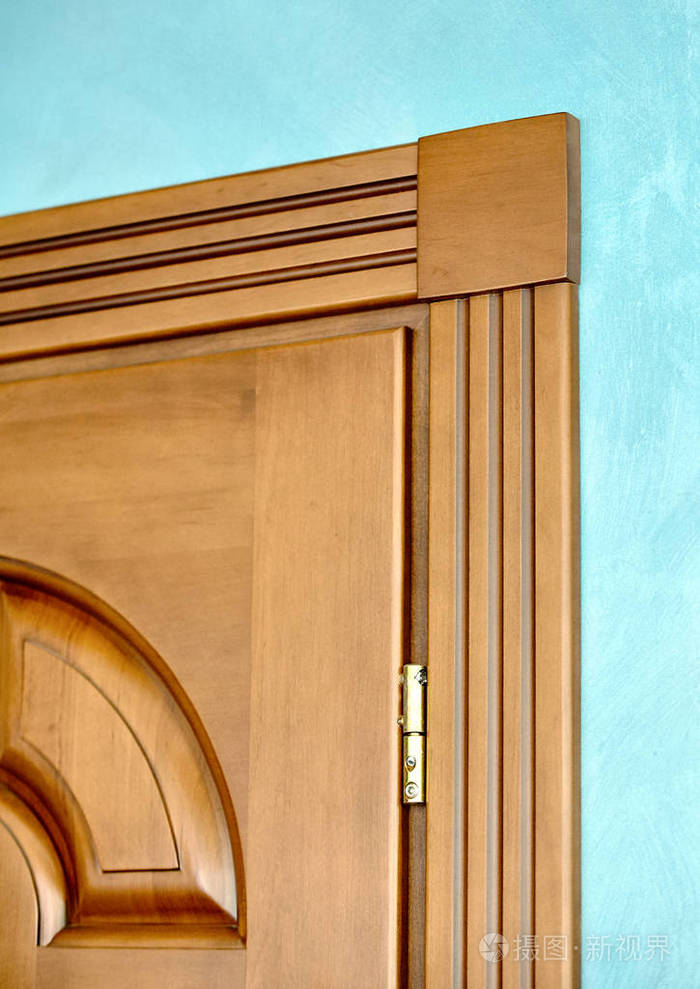 木门在褐色木框架中的元素雕刻几何饰品古典风格的镀金铰链在蓝色贴墙