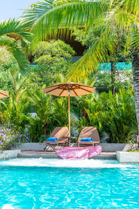 美丽的雨伞和椅子周围游泳池在酒店和度假胜地度假概念