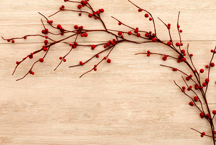 美丽的树枝上有红色浆果的木质背景。圣诞节装饰