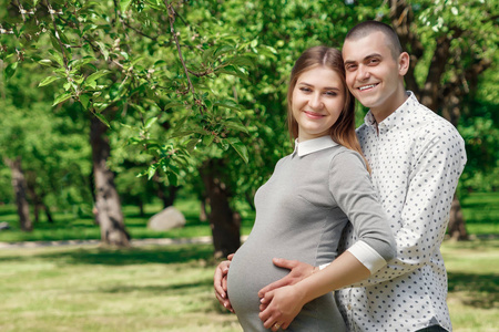 快乐的怀孕, 已婚夫妇在公园里。期待一个奇迹, 一个孩子。家庭生活, 孩子, 怀孕, 家庭, 父亲, 母亲