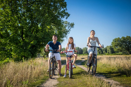 快乐微笑家庭骑自行车在农村路