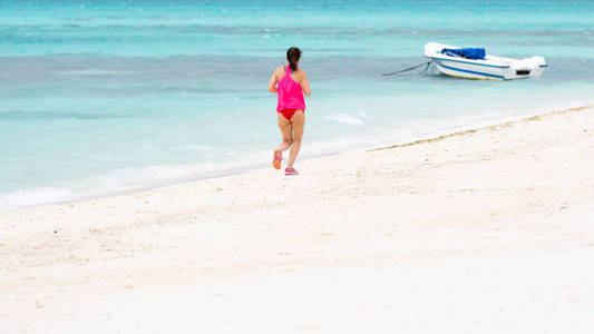 妇女奔跑在热带海滩, 女性赛跑者慢跑