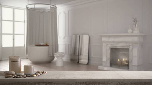 木制老式餐桌顶部或货架上的蜡烛和鹅卵石, 禅宗的心情, 在模糊经典浴室与浴缸和壁炉, 白色建筑室内设计