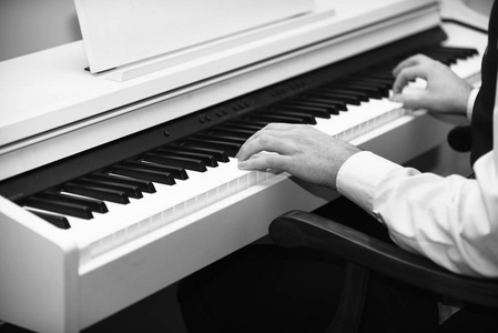 钢琴演奏者概念。男性手在白色钢琴背景下创作音乐