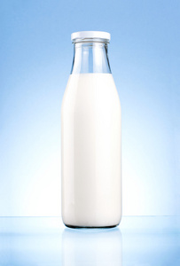 瓶的新鲜的牛奶被隔绝在一个蓝色的背景上