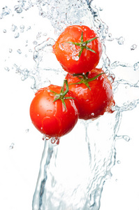 三个新鲜红番茄中飞溅的水隔离上白 ba