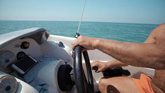 船长手转动方向盘在帆船上的关闭照片