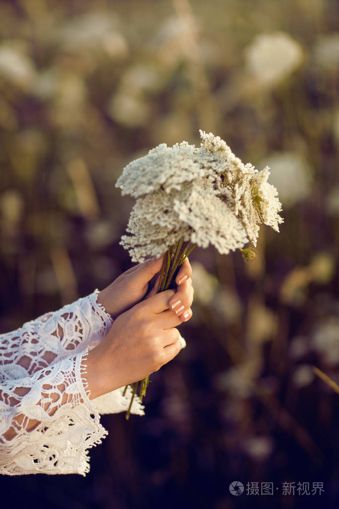 女人手捧着鲜花在田野里在原野上生活夏秋天心情波西米亚风格