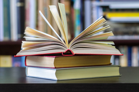 书架背景上的一本翻开的书照片