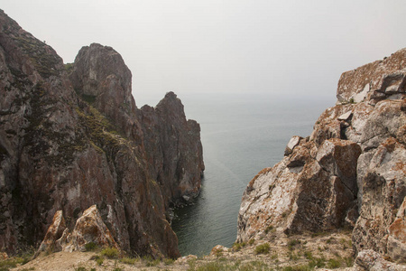 一座高高的岩石海岸线, 海中的悬崖, 湖水上的雾气