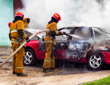 消防员扑灭燃烧的汽车火灾和汽车