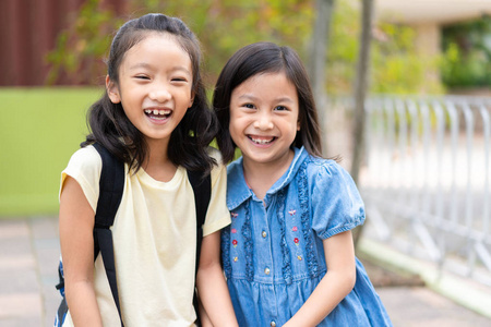 小亚洲女孩回到学校与朋友