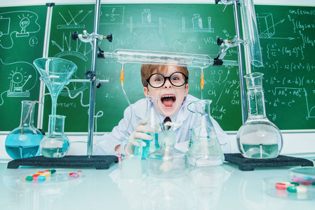在实验室里有趣的学校男孩科学家.教育理念照片