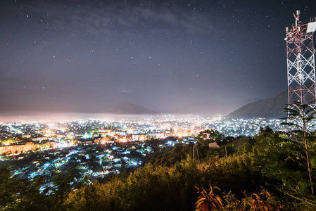 一座大明亮的城市在夜空下繁星满天, 许多灯笼和灯光, 夏日温暖的天气