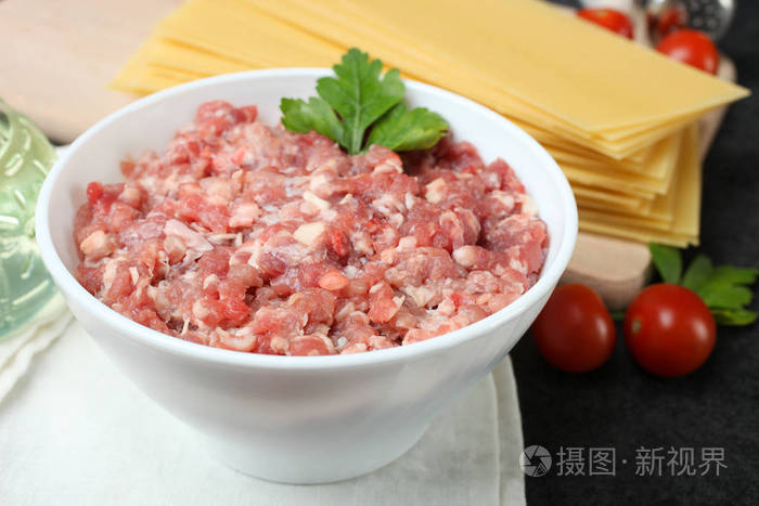 在黑色背景下烹调千层面的碎肉和其他配料