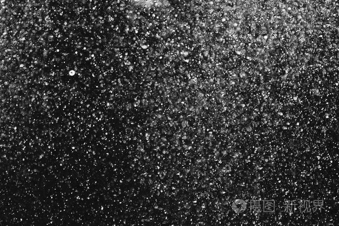 空气中的水滴在黑色背景上模糊不清