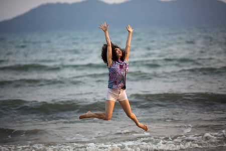年轻的混血女子跳上海边
