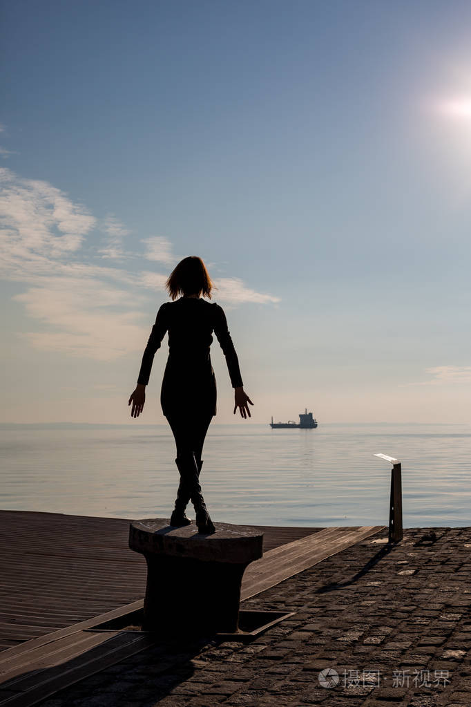 在希腊塞萨洛尼基的停靠杆上, 跳舞的年轻漂亮合身的女子的背部观看.