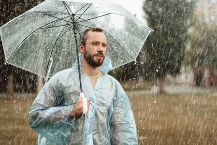 和心情对年轻的夫妇在雨中遛狗走在雨中的女孩秋天公园在雨中行走与伞
