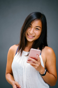 一个可爱的, 运动的, 晒黑的亚洲华人女孩的肖像, 在街上走着灰色的背景