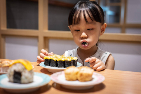 亚洲小中国女孩在日本餐厅吃寿司