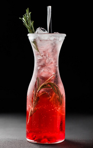 新鲜的红色草莓柠檬水与迷迭香和冰在玻璃罐子在黑暗的背景。夏日饮品和鸡尾酒