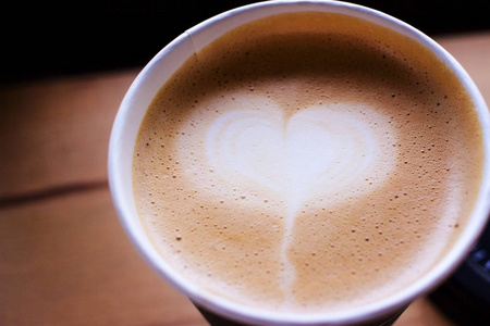 咖啡杯的咖啡馆与心脏拿铁艺术在顶部