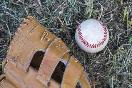 棒球手套和使用的棒球在绿色草
