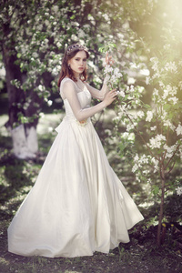 美丽的年轻新娘在盛开的花园里