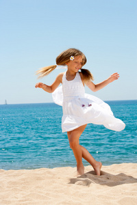 可爱的女孩，在沙滩上跳舞的白色礼服