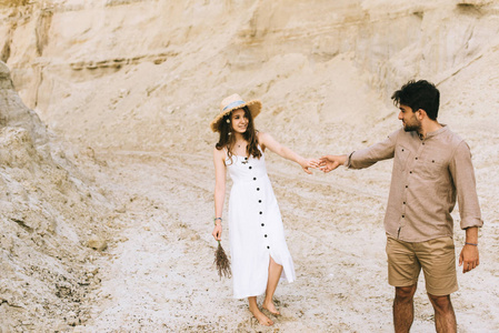 年轻时尚情侣牵手在沙峡谷