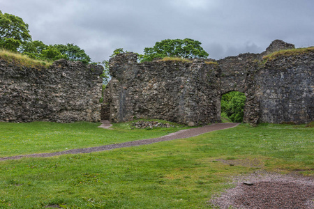 Torlundy, 苏格兰2012年6月11日 自然石门对 Inverlochy 城堡在威廉堡附近。绿草和灰色的天空。大长天