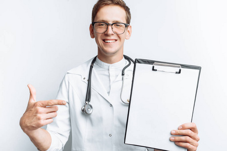 一个年轻的医生显示一个文件夹, 一个空白的工作表在相机上, 在白色的背景