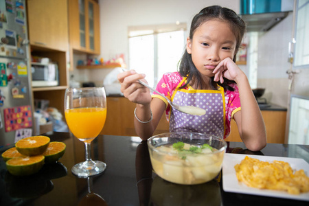 小亚洲女孩乏味吃食物和菜