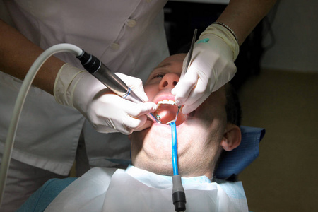 牙科牙齿抛光。牙齿清洁, 牙科卫生。牙科医生在他的牙医诊所和办公室用工具镜软牙刷和口吸管抛光病人牙齿