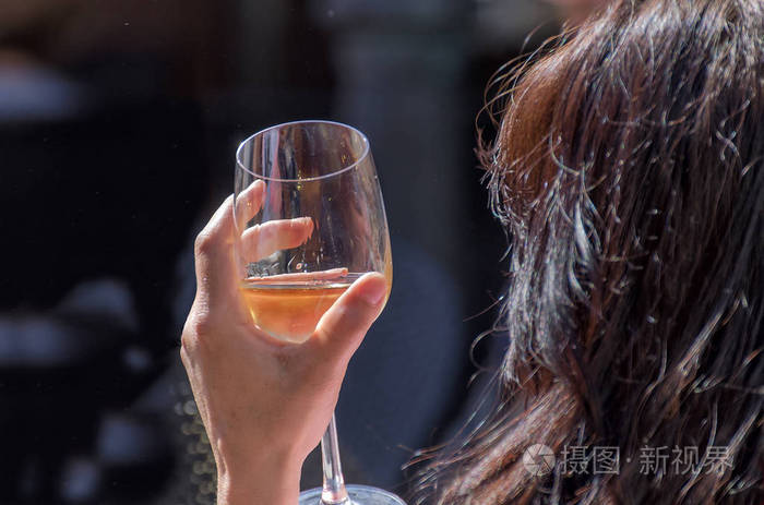 持有一个酒杯的女人