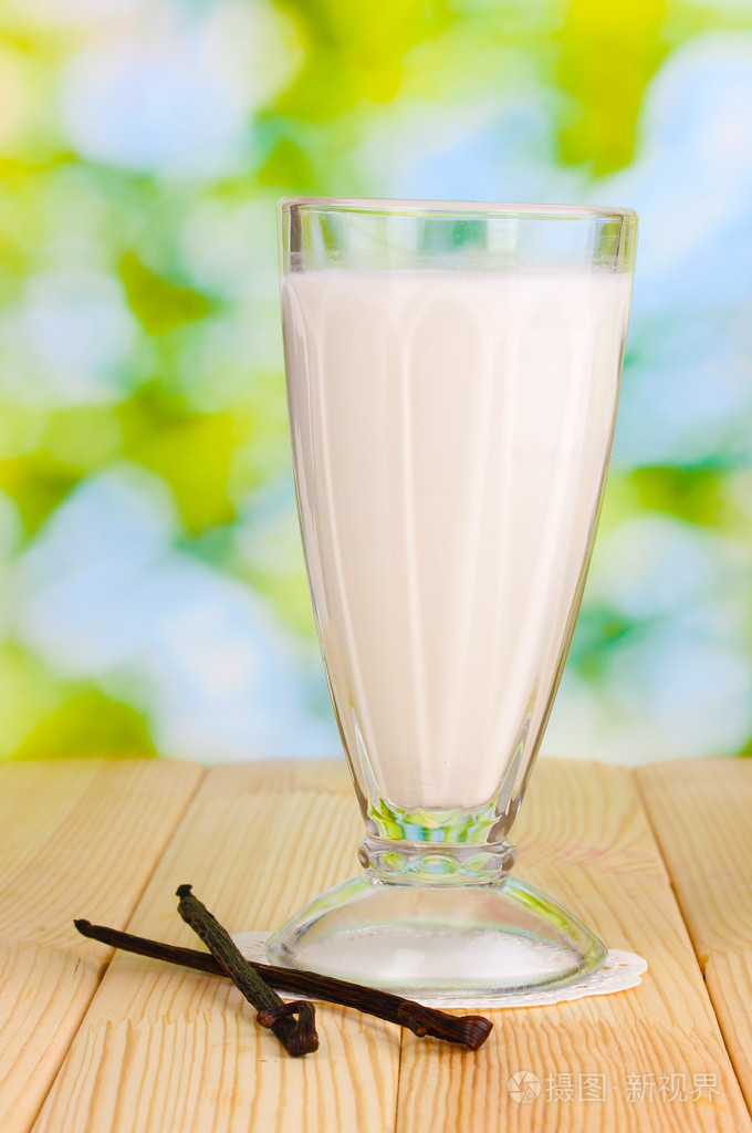 在明亮的背景上的木桌子上的香草奶昔