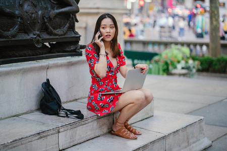 穿红色礼服的年轻妇女在电话图片