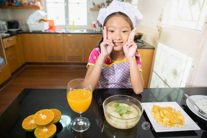 厨房里有健康食品和橙汁的小女孩