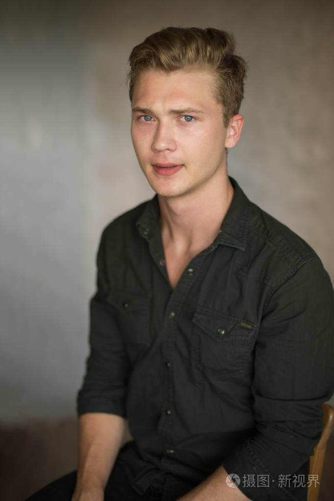 年轻的白人英俊的金发男子拍摄灰色背景