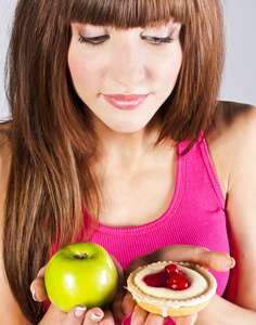 苹果和蛋糕在手里的女人