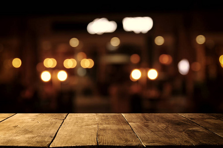 图像的抽象模糊餐馆前的木桌灯背景