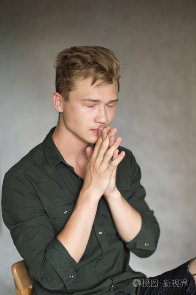 年轻的白人英俊的金发男子拍摄灰色背景