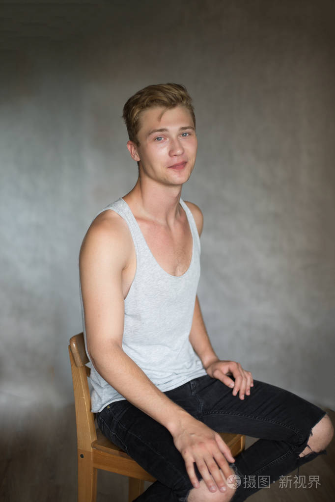 年轻的白人英俊的金发男子拍摄灰色背景