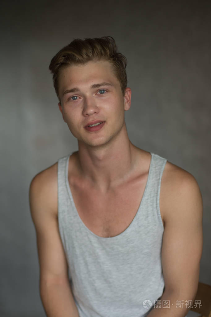 年轻的白人英俊的金发男子拍摄灰色背景