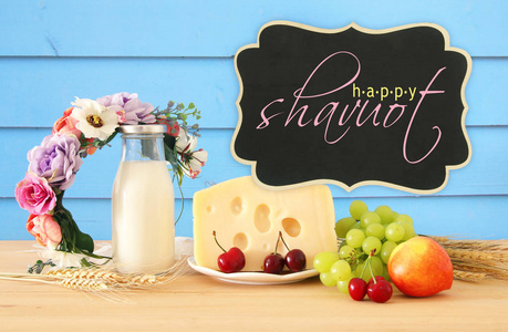 水果和奶酪的形象在装饰篮与花在木桌上。犹太节日的象征Shavuot