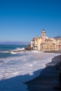大浪在 Camogli 的海滩上 breacking, 天空蔚蓝而晴朗。