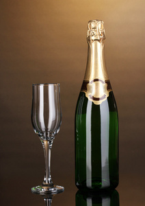 瓶香槟和棕色背景上酒杯